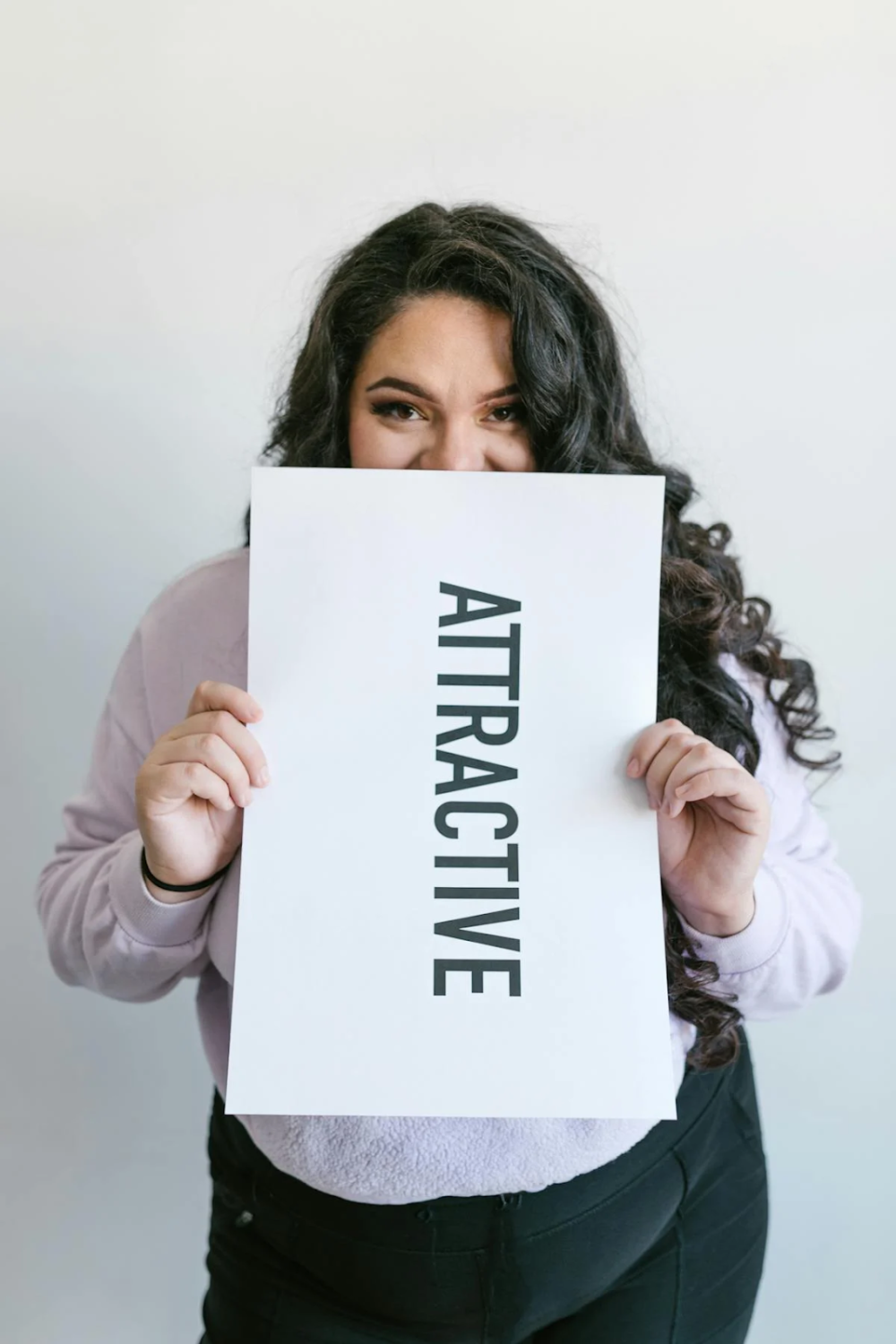 a woman holding a placard stating "attractive"