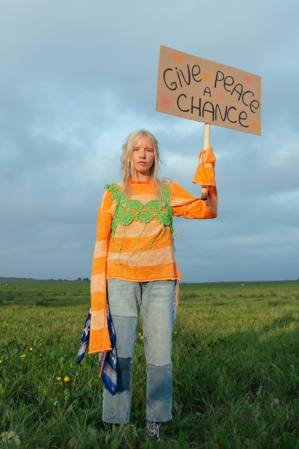 a woman holding a placard stating "give peace a chance"