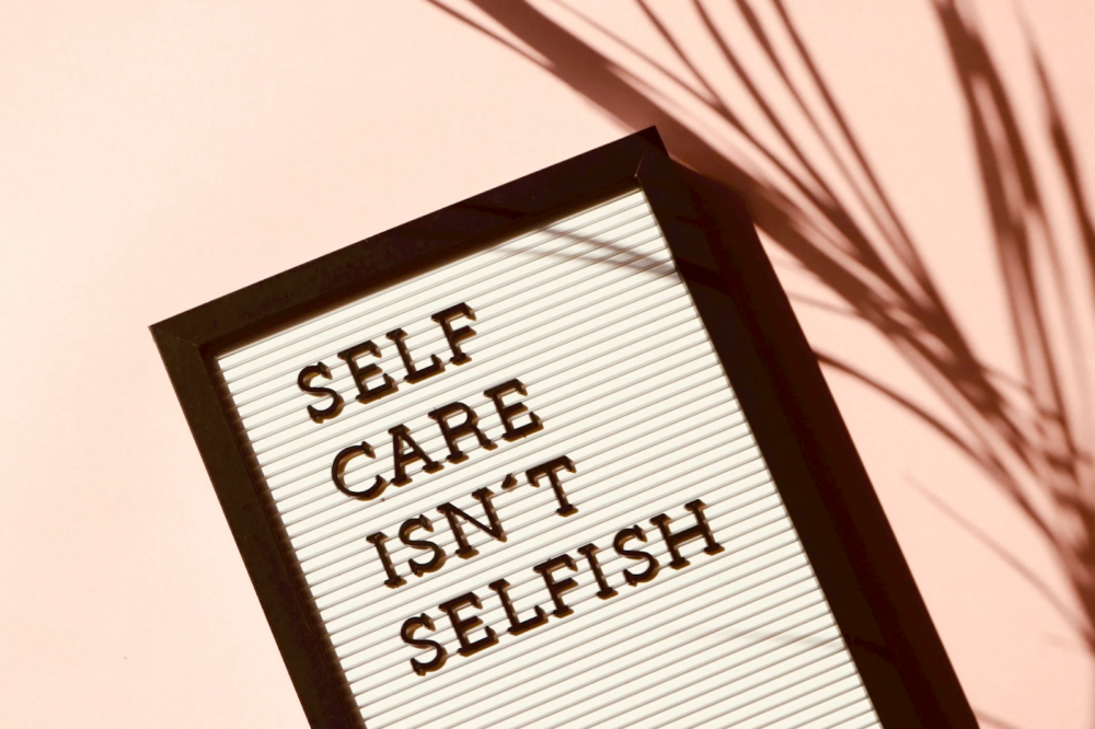 a placard stating self care isn't selfish