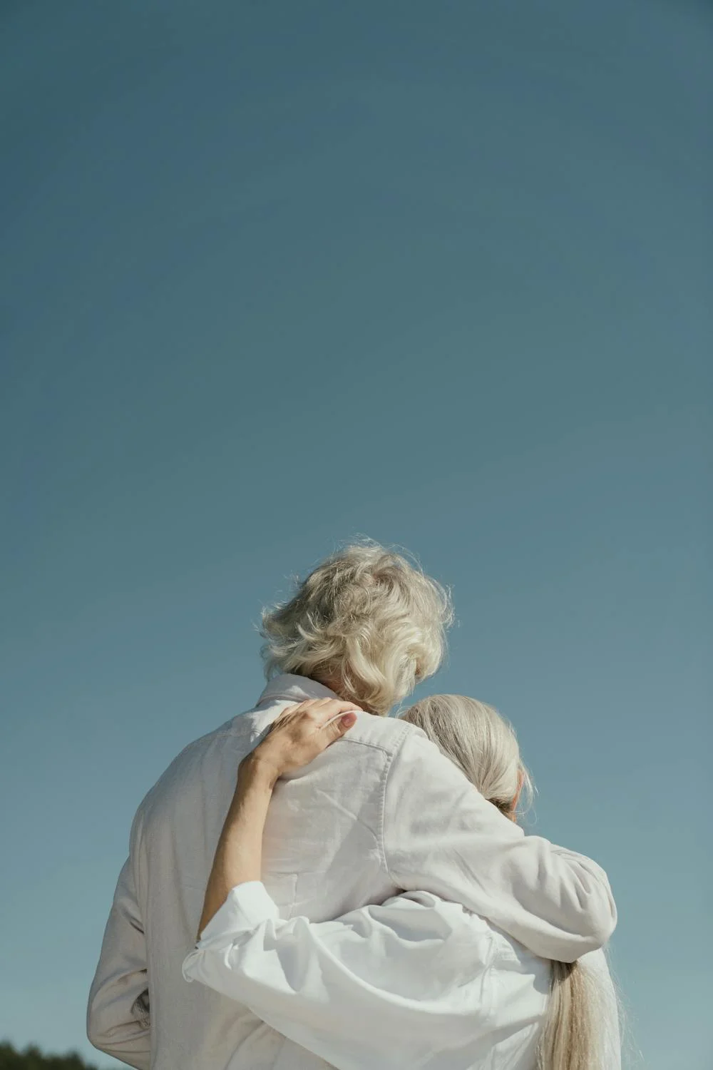 an elder couple holding each other