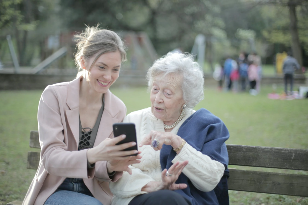 a young woman showing something to an old woman on her smartphone